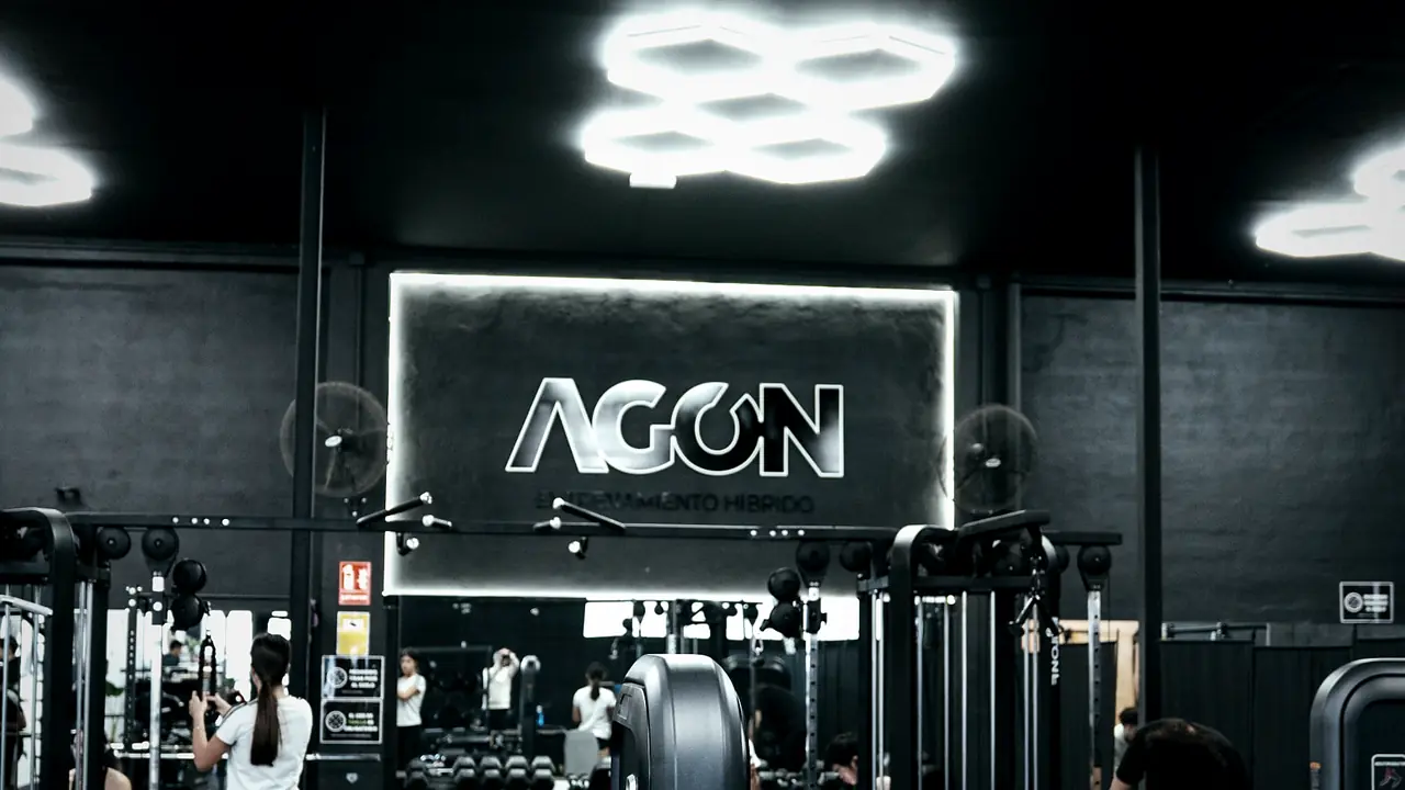 Sala de musculación de AGÓN Entrenamiento Castalla con máquinas y el logotipo iluminado